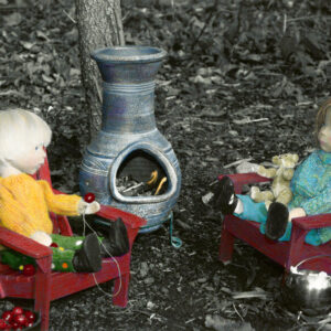 wooden dolls stringing cranberries by the fire drinking hot chocolate