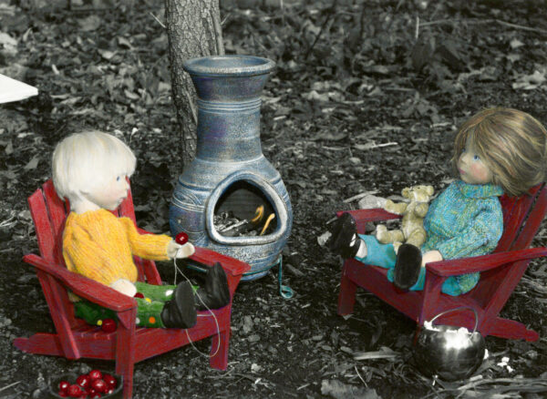 wooden dolls stringing cranberries by the fire drinking hot chocolate