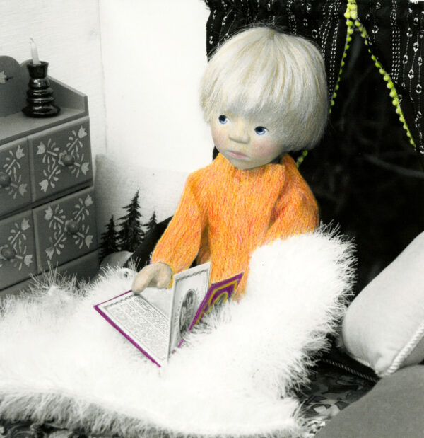 wooden doll reading a book