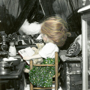 wooden doll reading by the stove